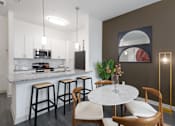 Thumbnail 2 of 25 - A kitchen with a bar area and a dining table.