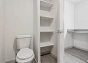 Thumbnail 25 of 38 - A white toilet is in a small bathroom with a white door.
