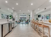 Thumbnail 1 of 19 - A modern kitchen with wooden floors and white countertops.