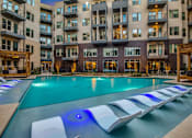 Thumbnail 2 of 26 - A large swimming pool with a blue light in the middle of it.