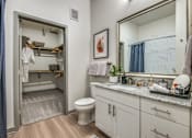 Thumbnail 17 of 26 - A bathroom with a toilet, sink, and mirror.