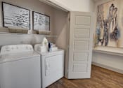 Thumbnail 11 of 36 - A laundry room with a washer and dryer.