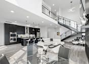 Thumbnail 13 of 35 - A modern kitchen with a glass table and stainless steel appliances.