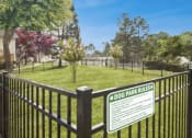 Thumbnail 11 of 16 - a dog park with a sign on a fence
