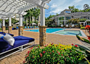 Thumbnail 17 of 25 - A pool area with sun loungers and a white pergola.