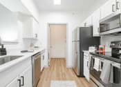 Thumbnail 19 of 41 - a renovated kitchen with white cabinets and stainless steel appliances
