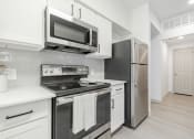 Thumbnail 9 of 35 - a kitchen with stainless steel appliances and white cabinets