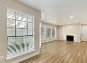 Thumbnail 4 of 28 - a living room with a fireplace and large windows