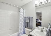 Thumbnail 29 of 31 - A white bathroom with a white tub, toilet, and sink.