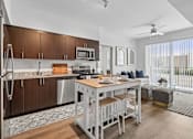 Thumbnail 1 of 34 - A modern kitchen with a dining table and chairs.