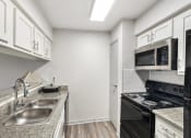 Thumbnail 4 of 34 - a kitchen with a sink and a stove and a microwave