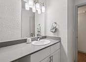 Thumbnail 22 of 38 - A bathroom with a sink and mirror.