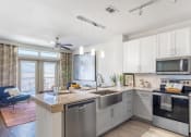 Thumbnail 2 of 33 - a kitchen with white cabinets and stainless steel appliances