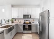 Thumbnail 3 of 33 - a kitchen with white cabinets and stainless steel appliances