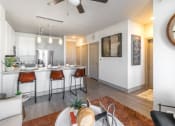 Thumbnail 16 of 33 - a living room and kitchen area with white walls and a ceiling fan