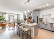 Thumbnail 7 of 33 - a kitchen and dining room with a large island and stainless steel appliances