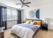 Thumbnail 11 of 33 - a bedroom with a large bed and a ceiling fan