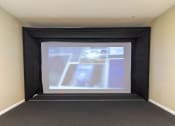 Thumbnail 32 of 33 - a large projection screen in a room with a carpeted floor