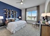 Thumbnail 9 of 36 - A bedroom with a large bed and a window overlooking a cityscape.
