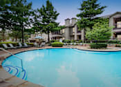 Thumbnail 13 of 28 - a swimming pool with an apartment building in the background