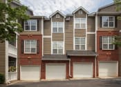 Thumbnail 7 of 17 - a brick apartment building with white garage doors