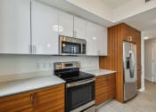 Thumbnail 39 of 66 - a kitchen with white countertops and wooden cabinets
