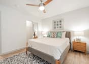 Thumbnail 10 of 17 - A bedroom with a bed, nightstand, and a ceiling fan.