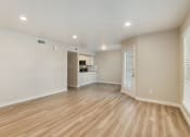 Thumbnail 9 of 28 - an empty living room with a kitchen in the background