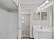 Thumbnail 54 of 54 - A white bathroom with a sink, mirror, and lighting.