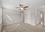 Thumbnail 52 of 54 - A room with a ceiling fan and carpeted floor.