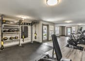 Thumbnail 20 of 20 - a home gym with weights and equipment and a door to a balcony