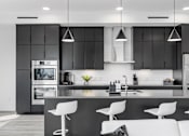 Thumbnail 17 of 35 - A modern kitchen with a black and white color scheme.