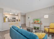 Thumbnail 6 of 23 - a living room and kitchen with a blue couch and yellow chairs