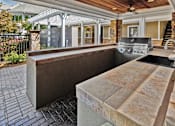 Thumbnail 21 of 25 - A patio with a grill and a sink.