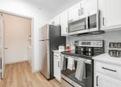 Thumbnail 21 of 41 - a kitchen with white cabinets and stainless steel appliances and a refrigerator