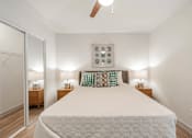 Thumbnail 9 of 17 - A bedroom with a large bed and two nightstands with lamps.