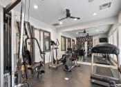 Thumbnail 24 of 32 - a gym with weights and cardio equipment in a home for sale