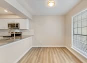 Thumbnail 7 of 28 - a kitchen with white cabinets and a large window