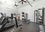 Thumbnail 10 of 14 - A spacious gym with treadmills, weights, and exercise equipment.