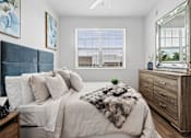 Thumbnail 10 of 34 - A bedroom with a large bed, a wooden dresser, and a window with blinds.
