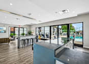 Thumbnail 17 of 26 - A modern room with a bar and a pool outside.