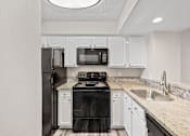 Thumbnail 37 of 54 - A black stove and oven in a kitchen with white cabinets.