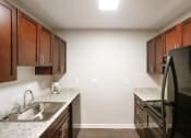 Thumbnail 3 of 16 - a kitchen with black appliances and granite counter tops