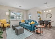 Thumbnail 5 of 23 - a living room with a blue couch and a dining room table
