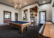 Thumbnail 22 of 28 - a game room with a pool table and a door to a bar