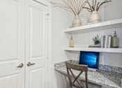 Thumbnail 16 of 34 - A white door is on the left and a desk with a laptop on it is on the right.
