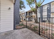 Thumbnail 28 of 38 - A black metal fence surrounds a concrete patio.