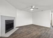 Thumbnail 21 of 43 - A room with a fireplace and a ceiling fan.