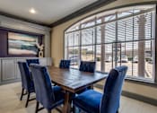 Thumbnail 10 of 25 - A dining room with a wooden table and blue chairs.