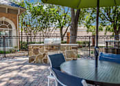 Thumbnail 22 of 25 - A patio with a table, chairs and a stone pillar.